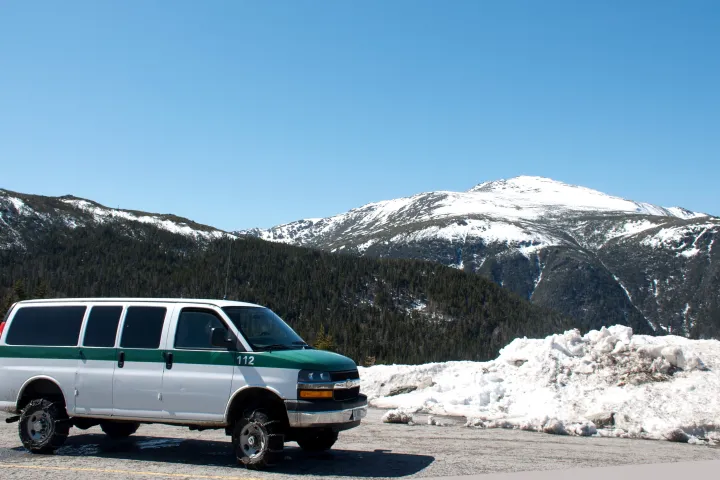 a car parked on the side of a snow covered mountain