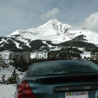 a car parked on the side of a snow covered mountain