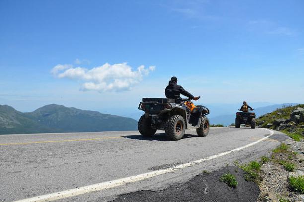 a man riding a motorcycle on the side of a road