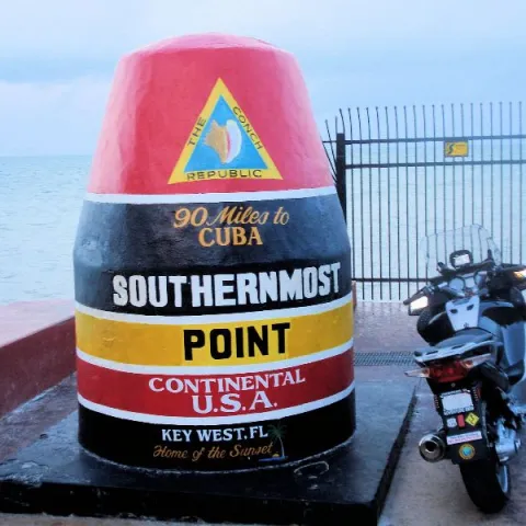 a bottle of water with Southernmost point buoy in the background