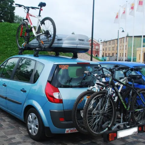 a bicycle parked in front of a blue car