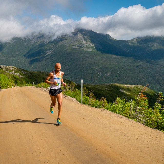 a man riding a bike down a dirt road