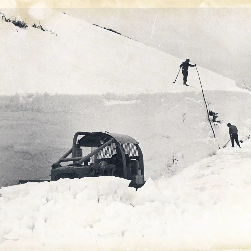 a man flying through the air on a snow covered slope