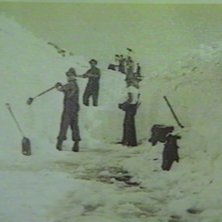 a man riding skis down a snow covered slope