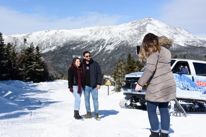 a group of people standing on top of a snow covered mountain