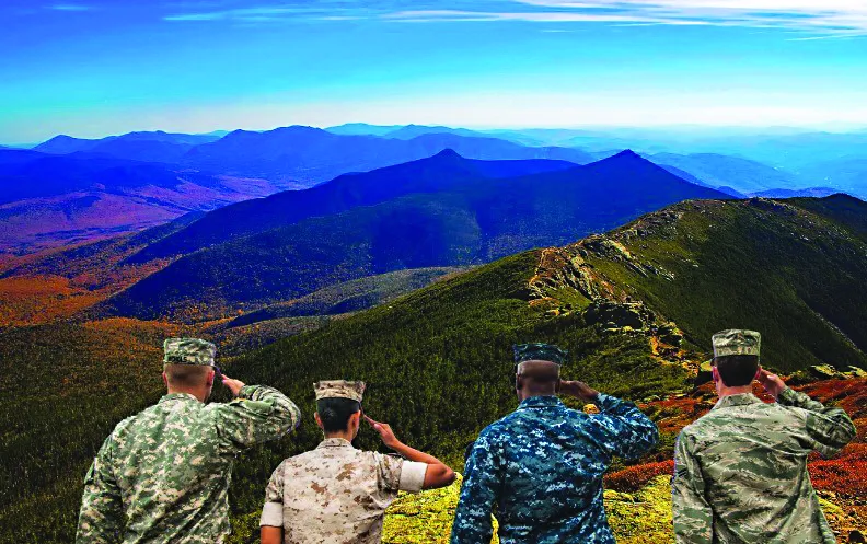 Four soldiers in different uniforms salute a mountain landscape.